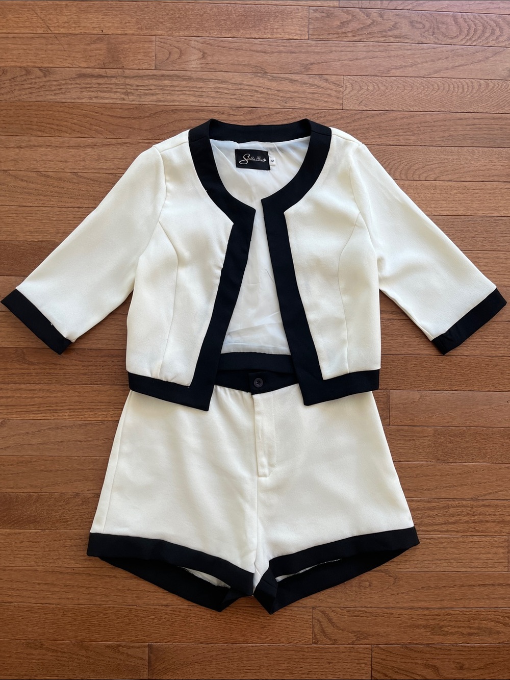 A set of Ivory and Black Two-Piece Cropped Jacket with High-Waist Shorts